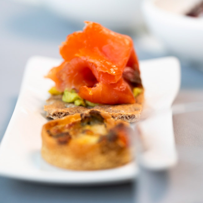 Tavola apparecchiata con dolce al cioccolato, antipasti e bicchiere d'acqua.