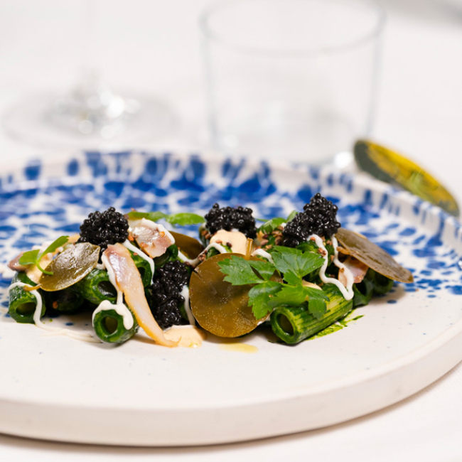 Elegantes grünes Pastagericht mit Kaviar und feinen Garnierungen.