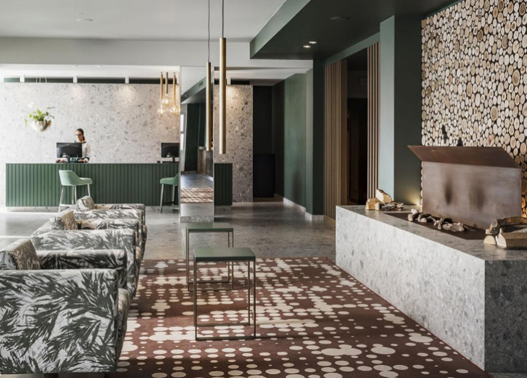 Moderno salotto con caminetto, arredi verdi e decorazioni naturali.