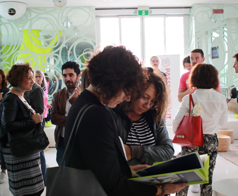 Gruppo di persone in conversazione animata, ambiente moderno e luminoso, atmosfera di curiosità e scambio.