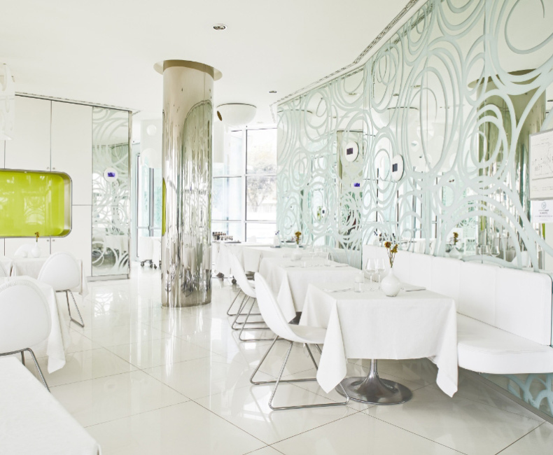 Ambiente futuristico, bianco e luminoso, con design moderno e dettagli eleganti.