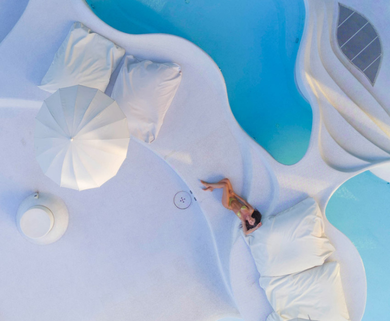 Piscina moderna con design organico e forme curve, riflettendo luce naturale.